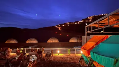 a group of chairs and a tent at night at SARH lUXURY CAMP in Wadi Rum