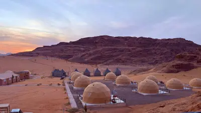a group of tents in the desert with a mountain at SARH lUXURY CAMP in Wadi Rum