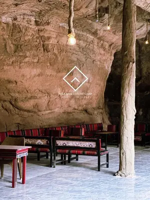 a group of benches sitting in a cave at ALYA RUM LUXURY Camp in Wadi Rum