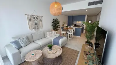 a living room with a couch and tables and a kitchen at Luxury apartments in Ayla in Aqaba