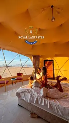a group of people laying on a bed in a tent at ROYAL LANCASTER lUXURY CAMP in Wadi Rum