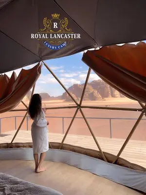 a woman standing in a tent looking out at the desert at ROYAL LANCASTER lUXURY CAMP in Wadi Rum