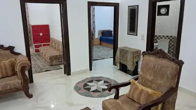 a living room with two chairs and a fireplace at فيلا سالم عبدالرحمن الأشــــــقــــر ابو حمزه Villa Salem Alashqar in Maḩaţţat al Jīzah