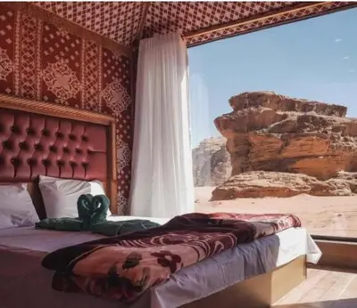 a bedroom with a bed with a view of the desert at Rum Magic Bubbles in Wadi Rum