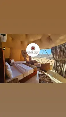 a bedroom with two beds and a large window at Thirteen Luxury Camp Valley in Wadi Rum