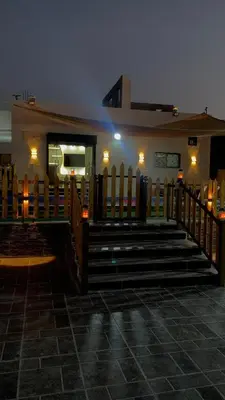 a church with a wooden fence and stairs at night at مزرعة الخربه in Khirbat Abū al Khass