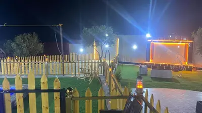 a fence with a screen in a park at night at مزرعة الخربه in Khirbat Abū al Khass