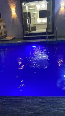 a swimming pool with blue water at night at مزرعة الخربه in Khirbat Abū al Khass