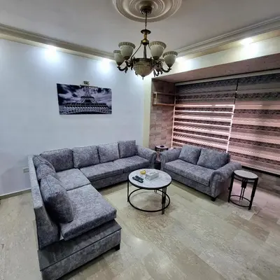 a living room with a couch and a table at Deir Ghbar Suite in Amman