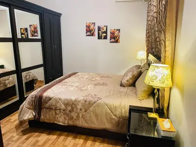 a bedroom with a bed and a lamp at شقة مفروشة بالجبيهة in Amman
