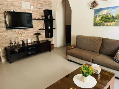 a living room with a couch and a tv on a brick wall at شقة مفروشة بالجبيهة in Amman