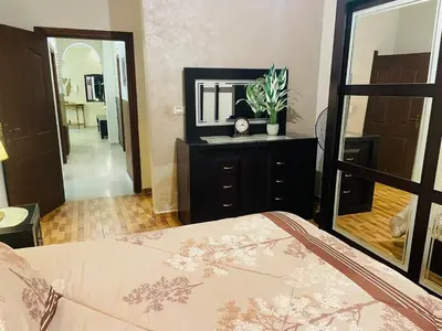 a bedroom with a bed and a large mirror at شقة مفروشة بالجبيهة in Amman
