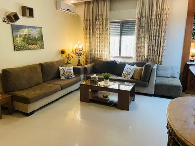 a living room with a couch and a table at شقة مفروشة بالجبيهة in Amman