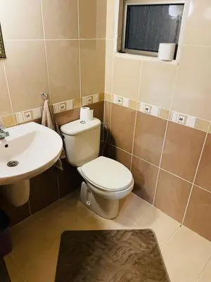 a bathroom with a toilet and a sink at شقة مفروشة بالجبيهة in Amman