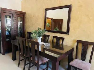 a dining room with a table and a mirror at شقة مفروشة بالجبيهة in Amman