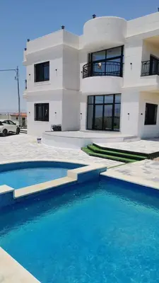 a house with a swimming pool in front of a building at شاليه ريست سي Rest Sea Chalet