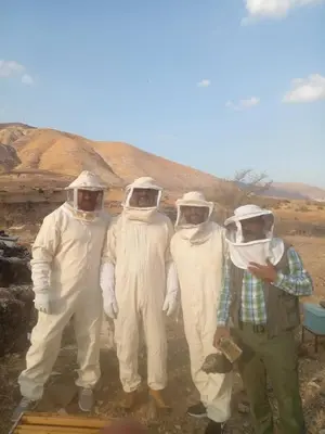 a group of four men in white suits posing for a picture at اربد ام قيس طريق درب الاردن in Um Qeis