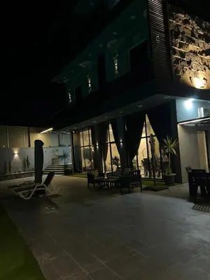 a building at night with benches in front of it at Villa Ohaio in Amman