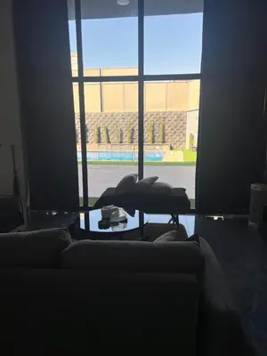 a living room with a couch and a large window at Villa Ohaio in Amman