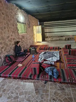 a group of people sitting on a bed in a room at Halfway motel in An Namatah