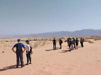 a group of people walking in the desert at Halfway motel in An Namatah