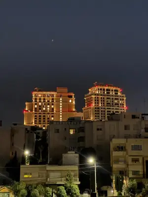 a group of buildings lit up at night at Roof 99 in Amman