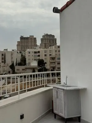 a sink on a balcony with a view of a city at Roof 99 in Amman