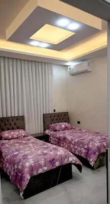 two beds in a room with pink blankets at For daily, weekly monthly and yearly stays in Amman