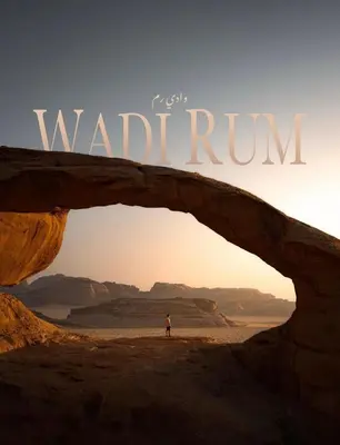 a person standing in front of a stone arch in the desert at Rum Laura luxury camp in Wadi Rum