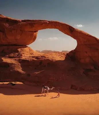 two people standing in the desert under an arch at Rum Laura luxury camp in Wadi Rum