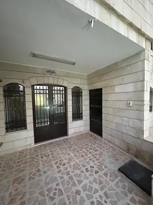 an empty room with black doors and a stone wall at Toum's Apartments 2 in Amman