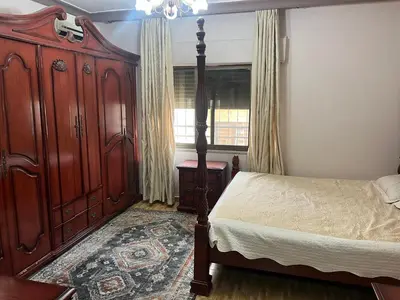 a bedroom with a bed and a large wooden cabinet at كرم الضيافة in Amman