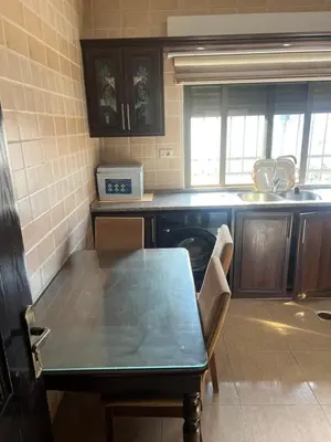 a kitchen with a table and a sink and a stove at كرم الضيافة in Amman