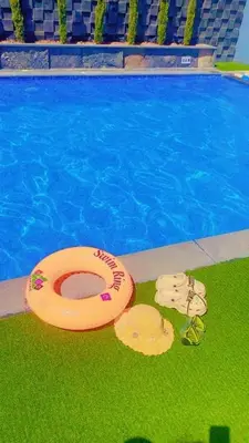 two frisbees on the grass next to a swimming pool at Ohio villa in Sowayma