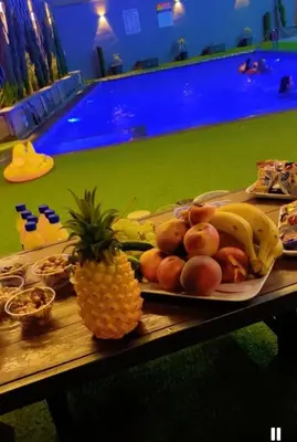 a table with a plate of fruit and a pineapple at Ohio villa in Sowayma
