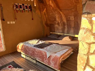a small room with two beds in a cave at Bedouin Secret Cave in Wadi Rum