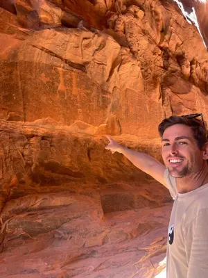 a man standing in front of a rock wall at Bedouin Secret Cave in Wadi Rum