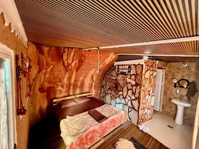a room with a bed in a cave style bedroom at Bedouin Secret Cave in Wadi Rum