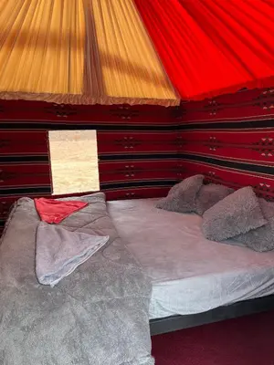 a bedroom with a bed with a red canopy at Desert Key Camp in Wadi Rum