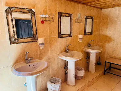 a bathroom with two sinks and two mirrors at Desert Key Camp in Wadi Rum