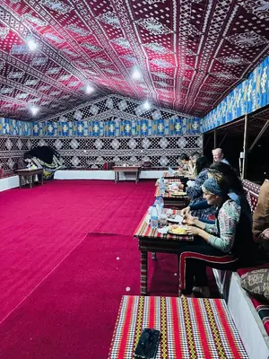 a group of people sitting at tables in a room at Desert Key Camp in Wadi Rum