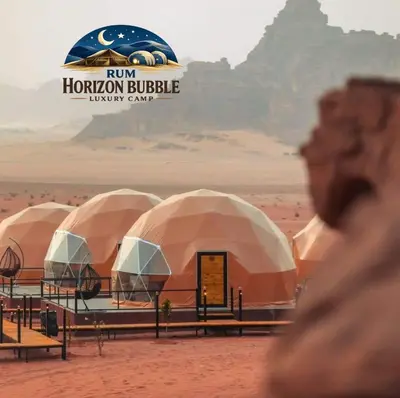 a group of domes in the desert with a sign that reads run horizons at RUM HORIZON BUBBlE LUXURY CAMP in Wadi Rum