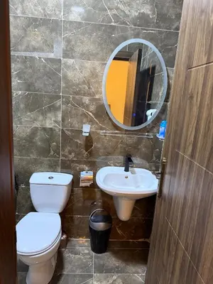a bathroom with a toilet and a sink and a mirror at 2bd apartment sport city in Amman