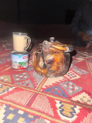 an old purse sitting on the floor with a cup of coffee at Sleeping amidst the natural beauty of Wadi Rum, and living like a Bedouin in Aqaba