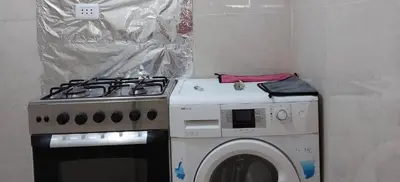a kitchen with a stove and a washing machine at Stone house in Amman
