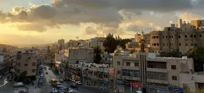 a city with buildings and cars on a street at Stone house in Amman