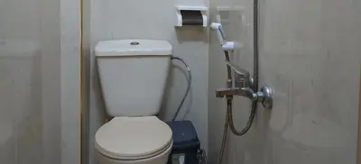 a bathroom with a white toilet and a phone at Stone house in Amman