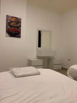 a white bedroom with a bed and a tv at dabouq 3bedroom near all services JRE in Amman