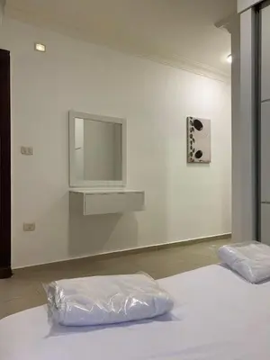 a white room with a mirror and a bed at Luxurious 3 Bedroom Apartment in Heart of Amman in Amman