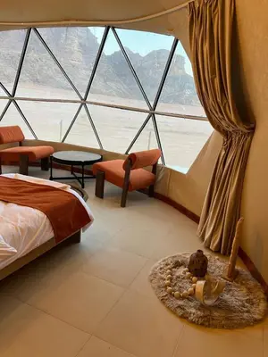 a bedroom with a bed and a large window at Rum Horizon Camp& Tours in Wadi Rum
